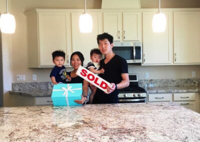 family of four holding a sold sign