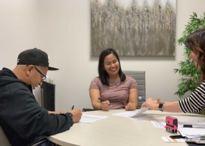 man and woman smiling while signing documents