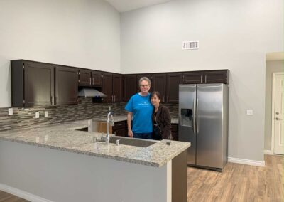a man and a woman standing inside a kitchen