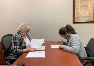 a female client signing papers after purchasing a property